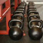 Black kettlebells lined up in a gym, ready for fitness training.