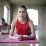 Two women engaged in planking exercises indoors demonstrating focus and fitness.