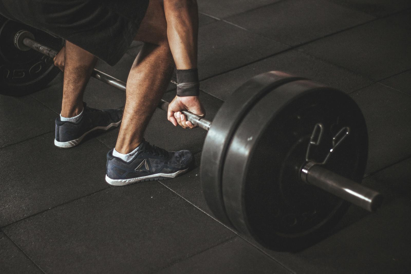 A man lifting a heavy barbell during a gym workout, showcasing strength and fitness.