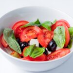 red and green bell pepper on white ceramic bowl