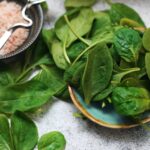 a plate of spinach and a bowl of rice