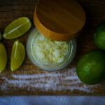 limes, sugar, and lime slices on a cutting board