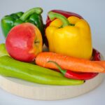 red and green bell pepper and red apple on white plate